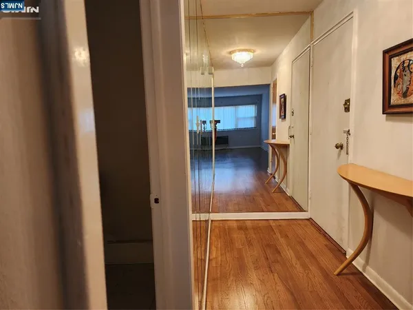 a view of a hallway with wooden floor and furniture