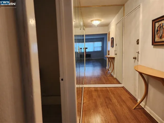 a view of a hallway with wooden floor and furniture