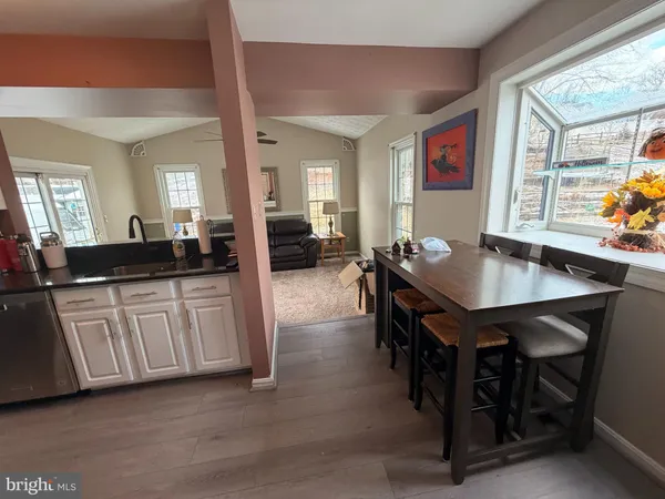 a kitchen with a table chairs and wooden floor