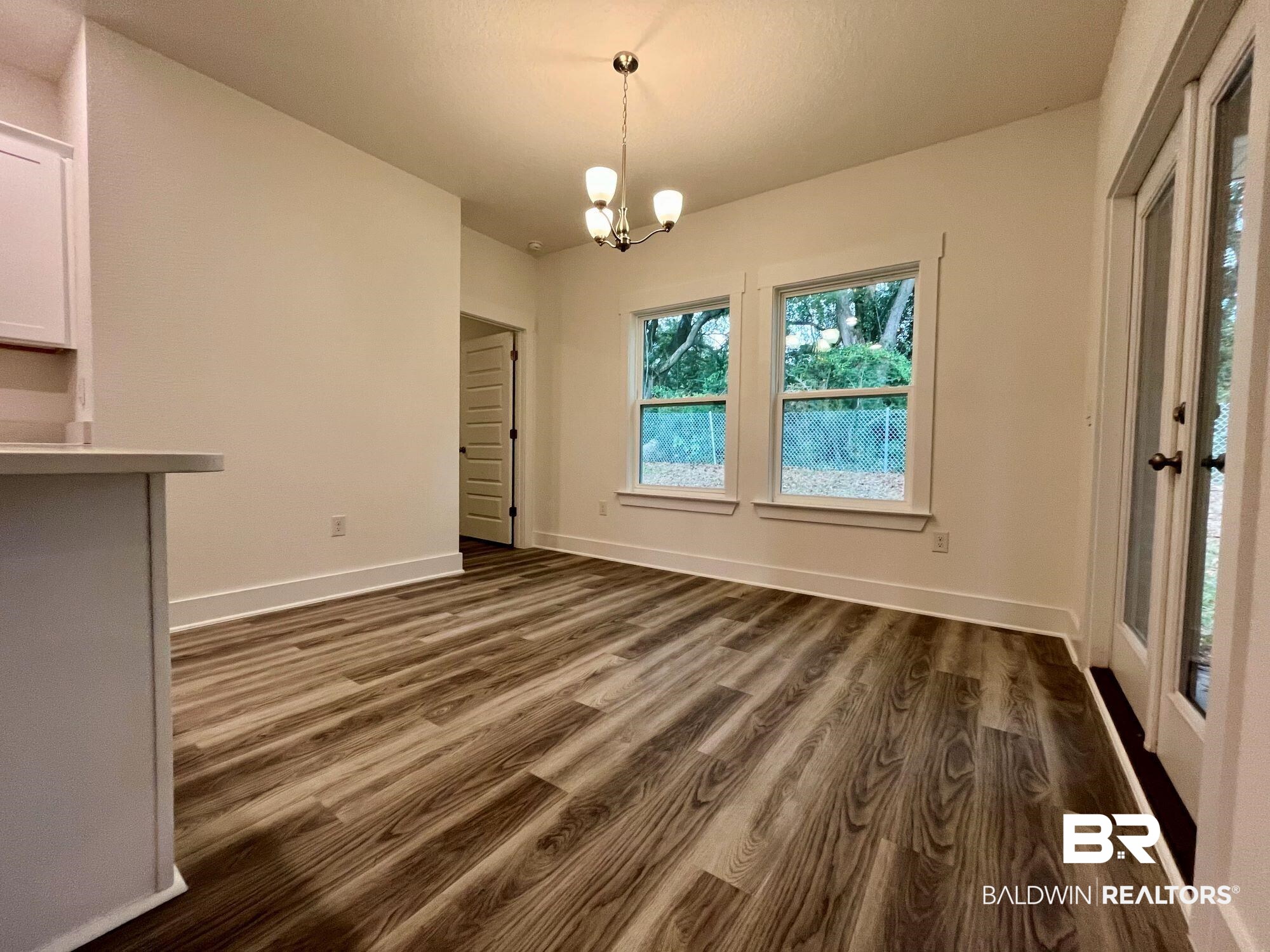 334 Barndling Street Fairhope, AL 36532 - Photo 13 of 34 Unfurnished dining area featuring dark hardwood / wood-style floors and an inviting chandelier
