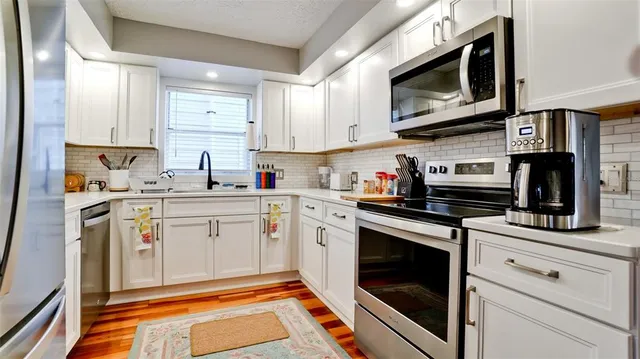 a kitchen with stainless steel appliances granite countertop a sink and cabinets