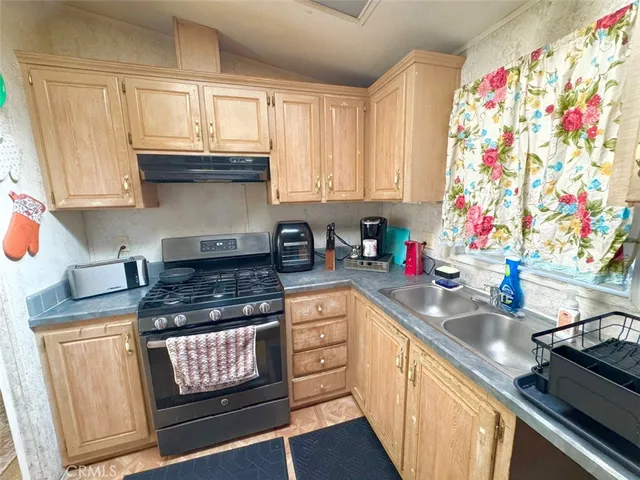 a kitchen with stainless steel appliances granite countertop a sink stove and cabinets
