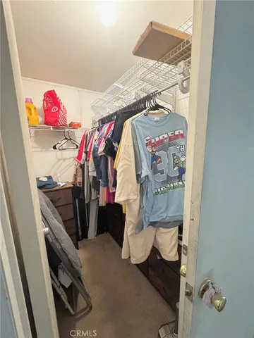 a view of walk in closet with clothes and shoes