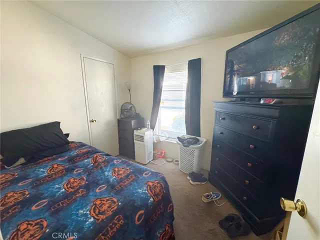 a bedroom with a bed and a mirror on dresser