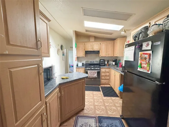a kitchen with stainless steel appliances granite countertop a stove a sink and a refrigerator