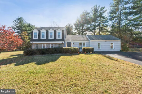a front view of house with yard and trees around