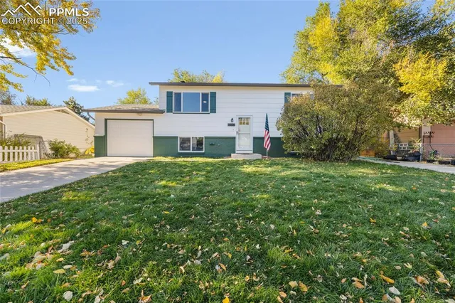 a view of a house with a big yard and large trees