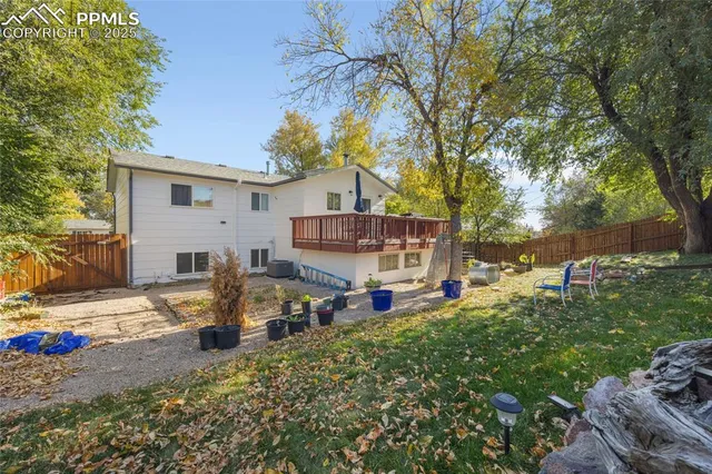 a view of a house with backyard wooden house and a tree