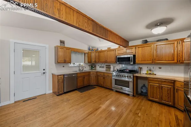 a kitchen with stainless steel appliances granite countertop lots of counter top space a sink and cabinets