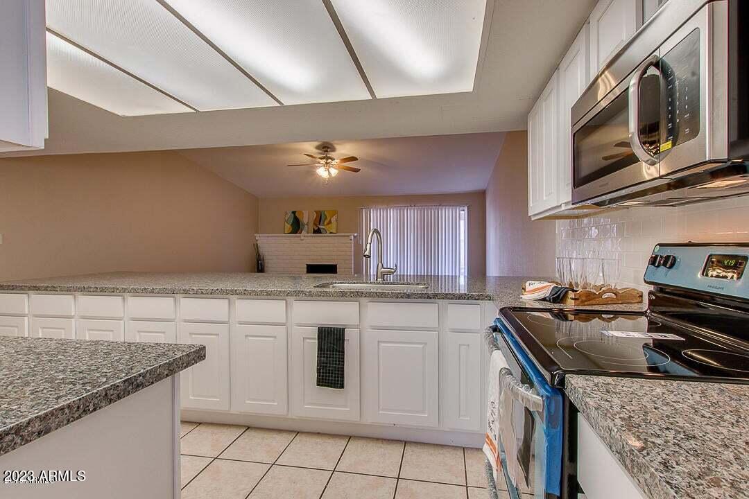 6521 West Camelback Road Phoenix, AZ 85033 - Photo 4 of 32 a kitchen with stainless steel appliances granite countertop a sink stove and cabinets