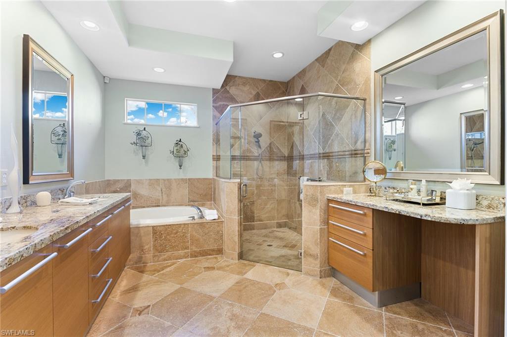 540 Ketch Drive Naples, FL 34103 - Photo 5 of 32 a spacious bathroom with a bathtub sink and mirror