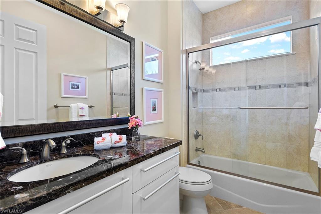 540 Ketch Drive Naples, FL 34103 - Photo 7 of 32 a bathroom with a granite countertop sink a toilet a mirror and shower