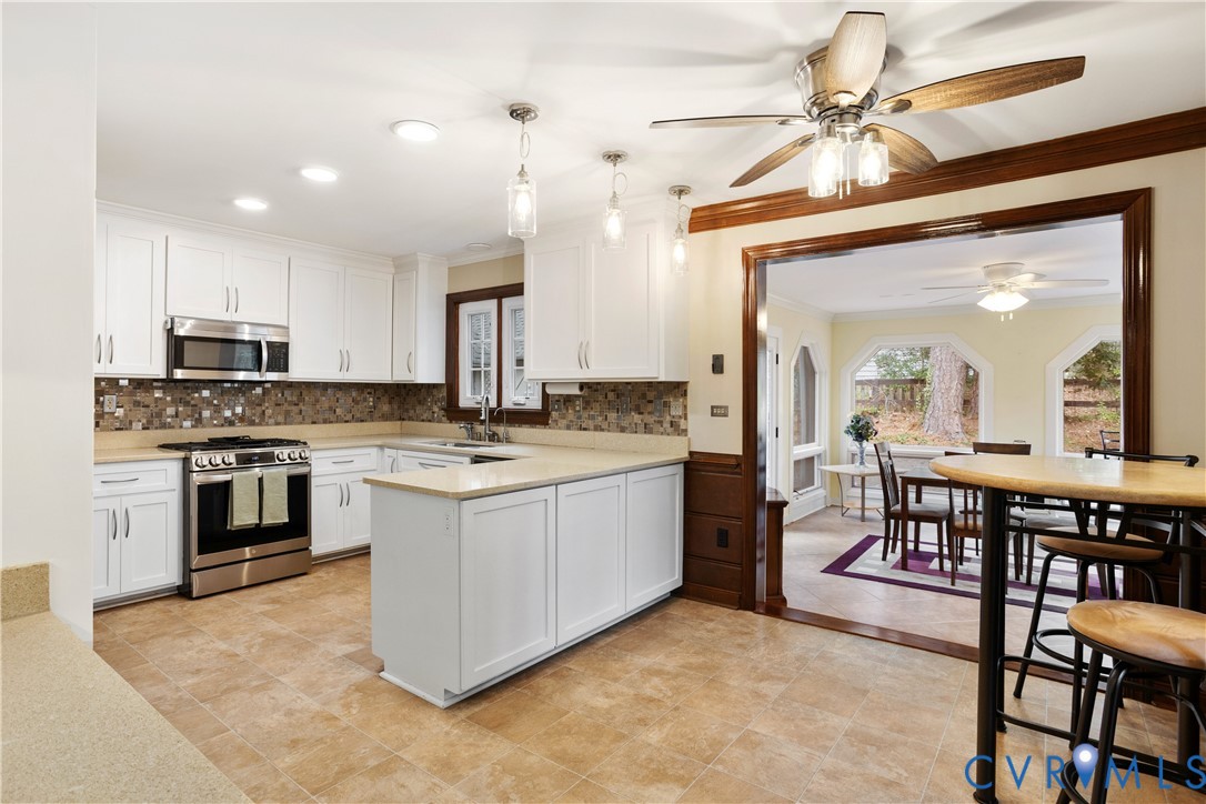 3613 Stoney Ridge Road Midlothian, VA 23112 - Photo 12 of 50 a kitchen with kitchen island granite countertop a stove a sink a dining table and chairs