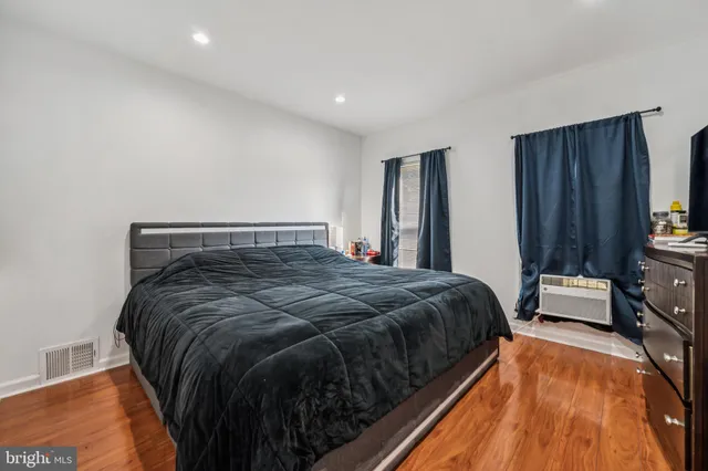 a bed sitting in a bedroom and wooden floor