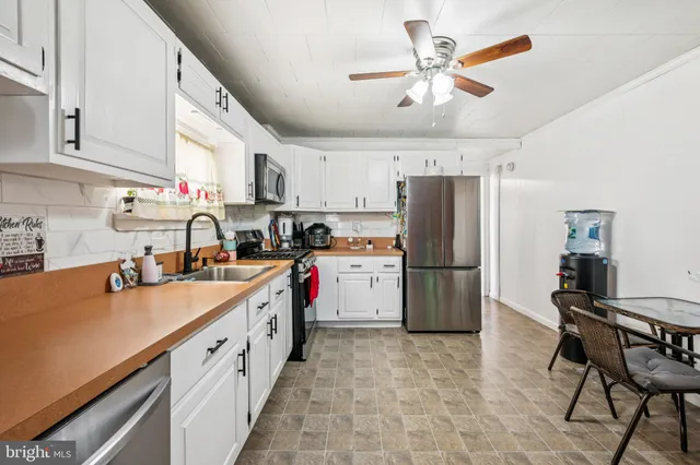 a kitchen with a sink a refrigerator and cabinets