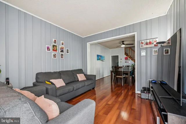 a living room with furniture a wooden floor and a flat screen tv