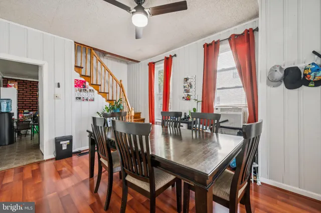 a dining room with wooden floor a chandelier a wooden table and chairs