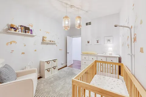 a living room with furniture and a baby crib