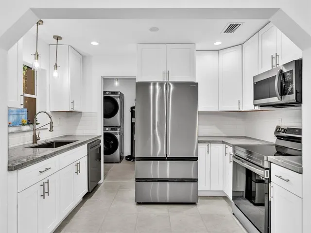 a large kitchen with a large window and stainless steel appliances