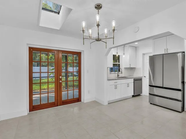 a view of an empty room with window and cabinet