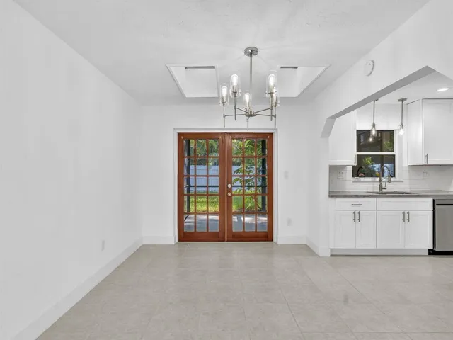 a dining room with furniture a chandelier and window