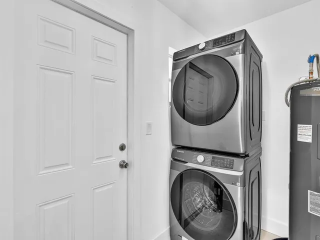 a view of a house with small yard plants and large tree