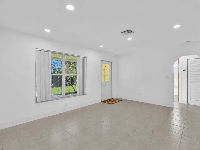 an empty room with windows and ceiling fan