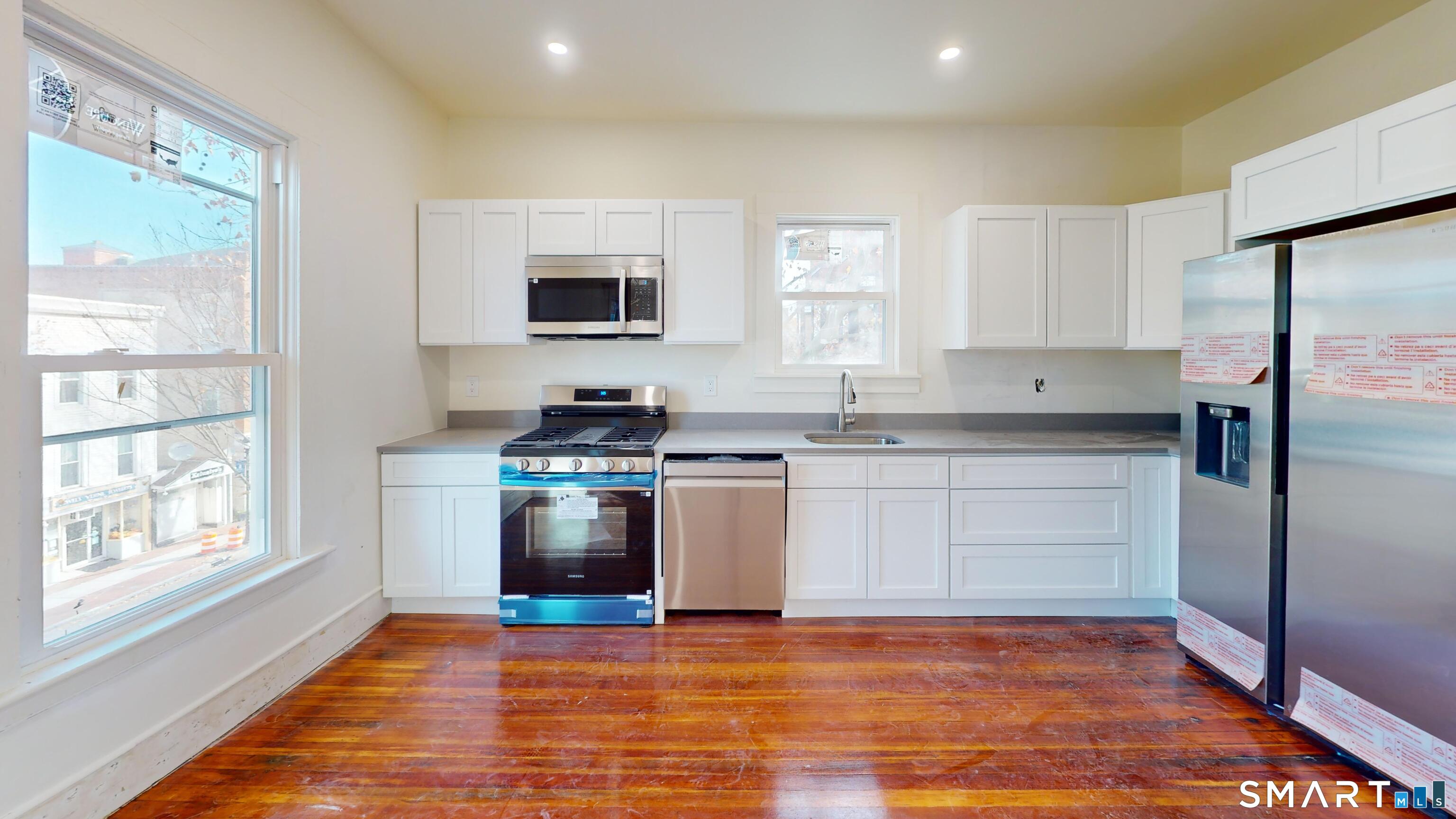 a kitchen with stainless steel appliances granite countertop a stove a sink and a refrigerator