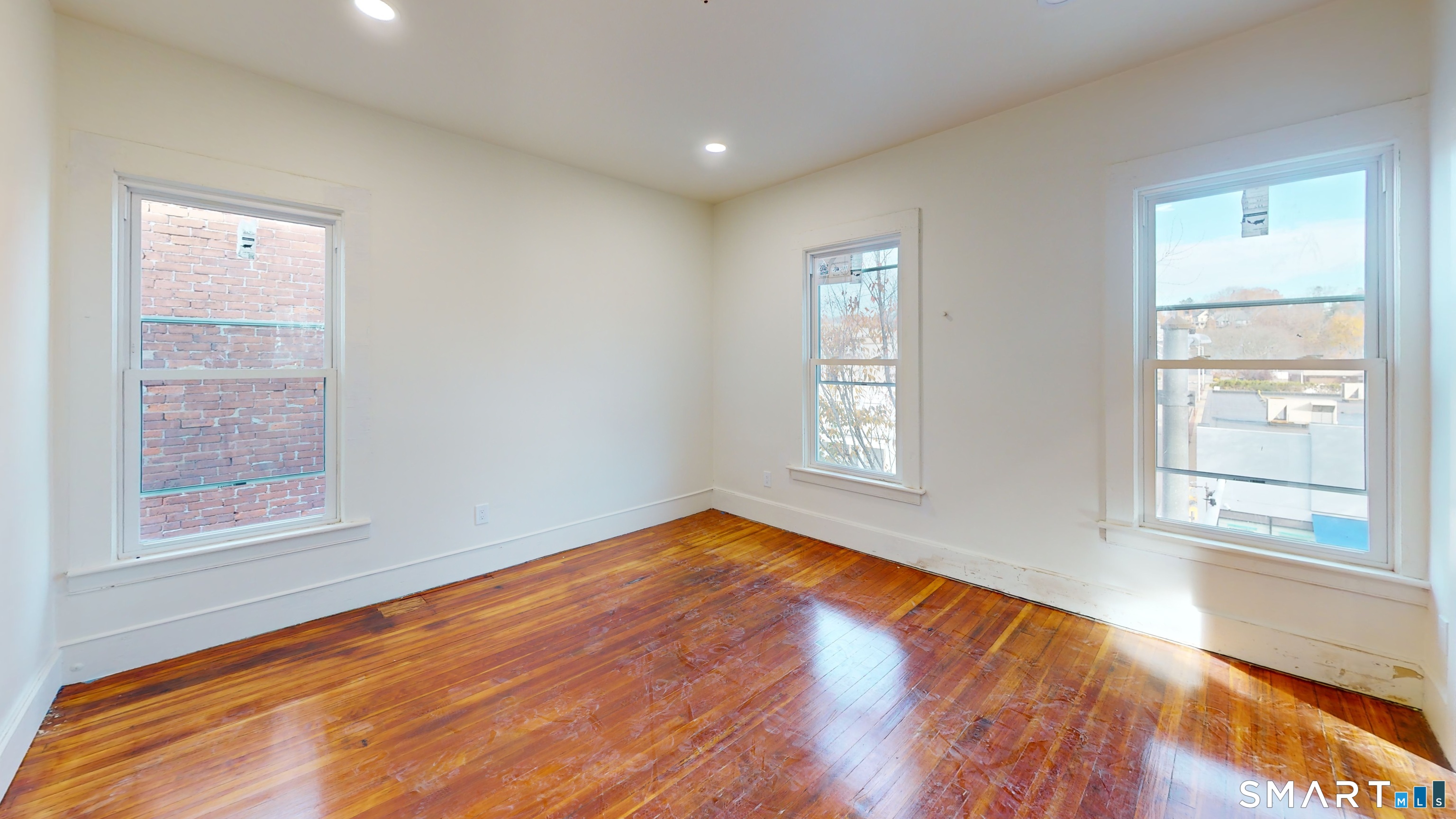 736 Main Street Windham, CT 06226 - Photo 12 of 12 an empty room with wooden floor and windows
