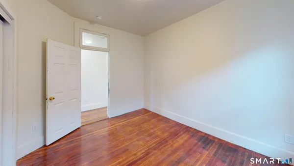 a view of an empty room with wooden floor