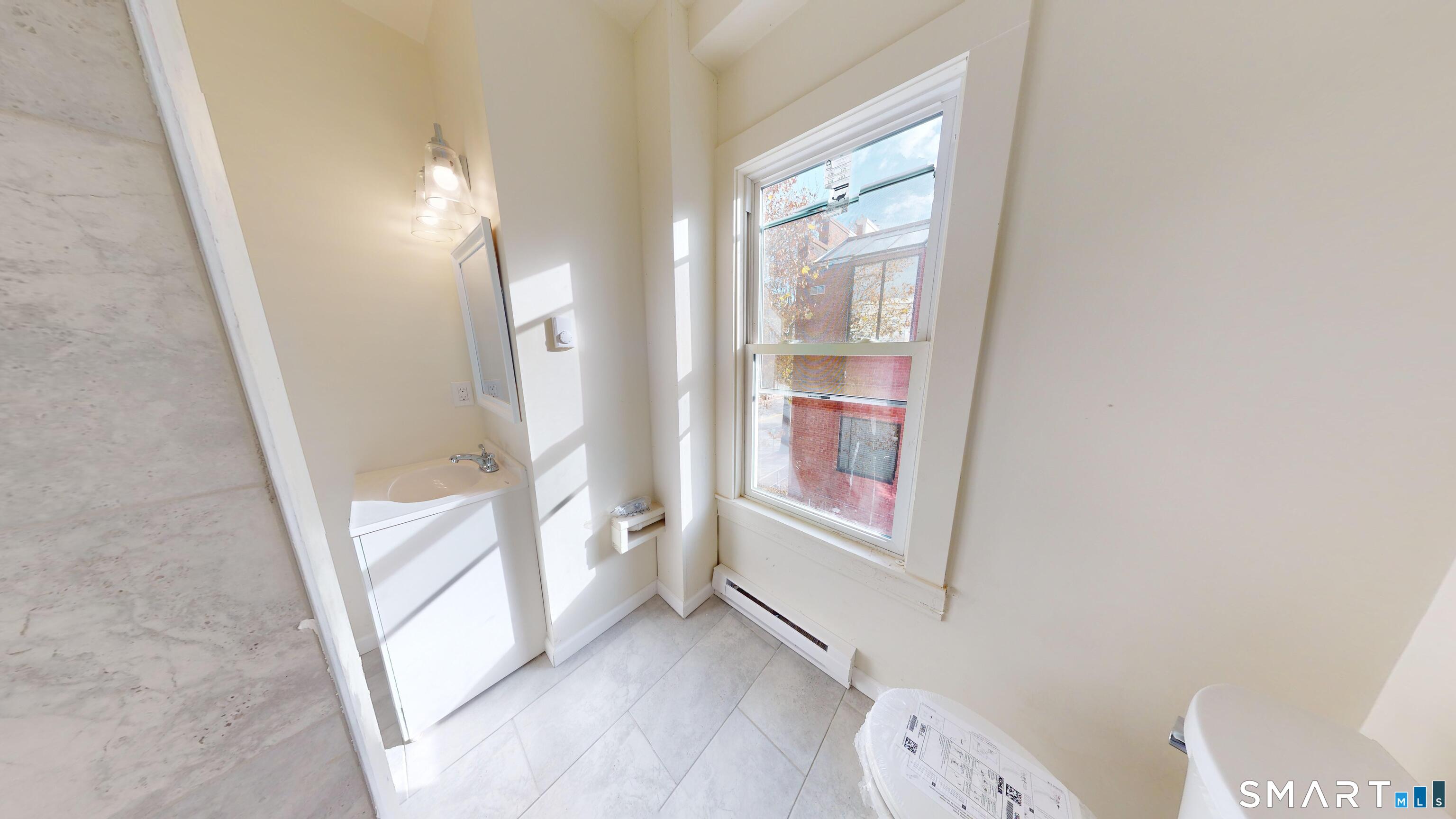 736 Main Street Windham, CT 06226 - Photo 6 of 12 an entryway with wooden floor and a bathroom