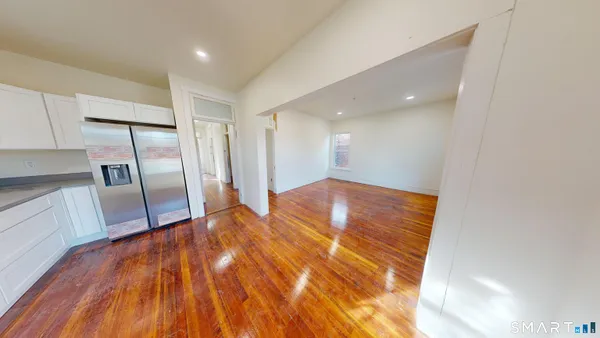 a view of empty room with wooden floor