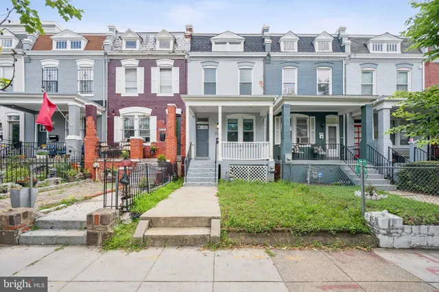 a front view of a residential apartment building with a yard