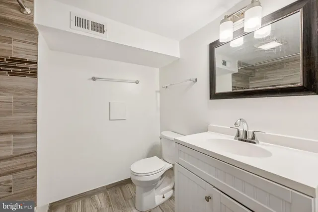a bathroom with a toilet a sink and mirror