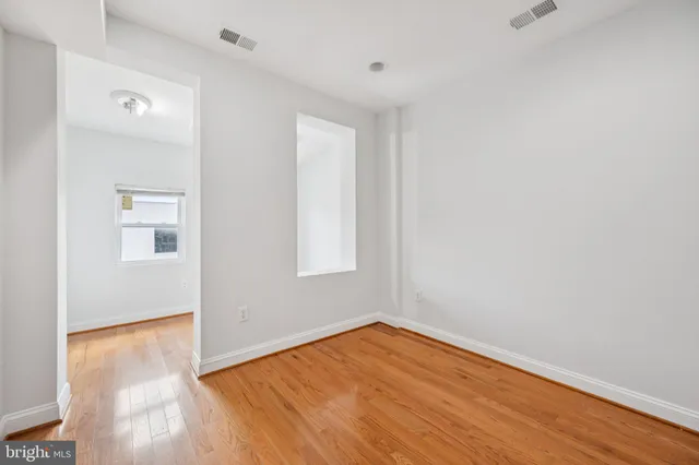 a view of empty room with wooden floor