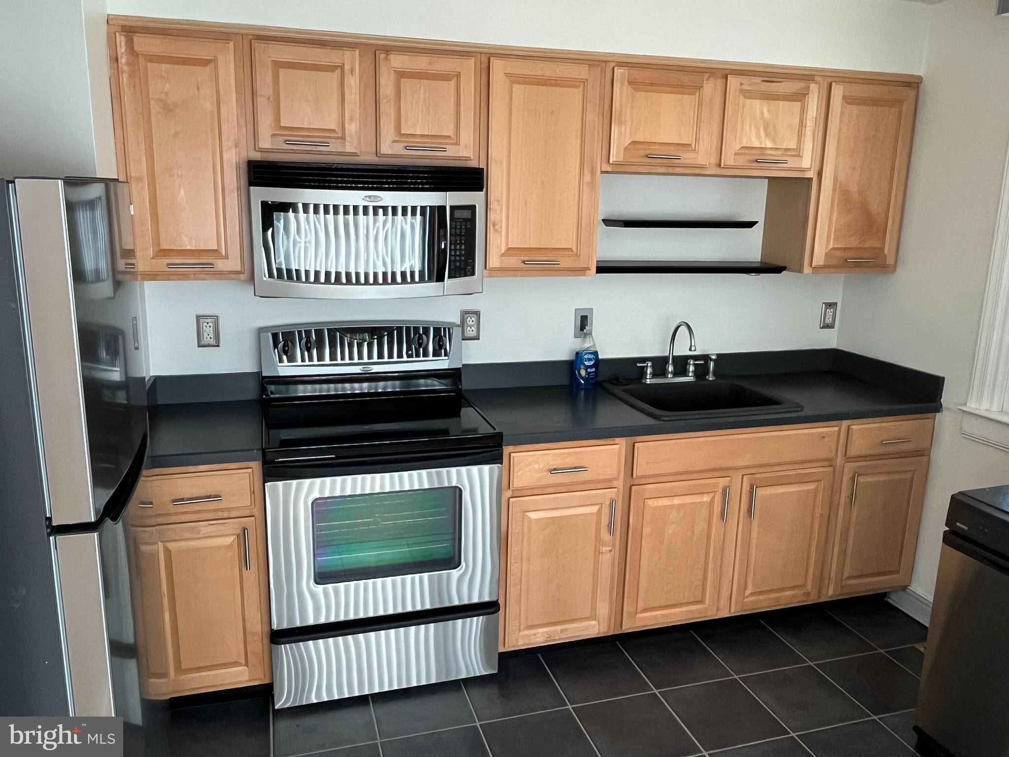 509 Larkspur Street Philadelphia, PA 19116 - Photo 5 of 15 a kitchen with stainless steel appliances a stove a sink and a microwave