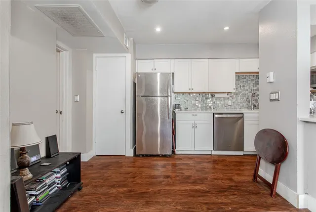 a living room with furniture and kitchen view