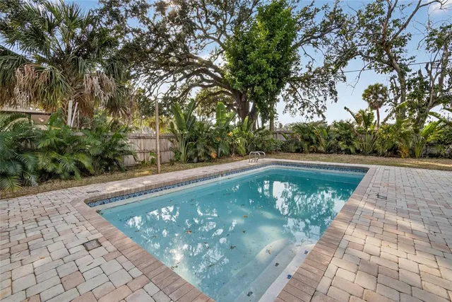 a view of a house with backyard and trees