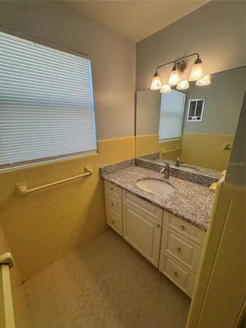 a bathroom with a granite countertop sink and a mirror