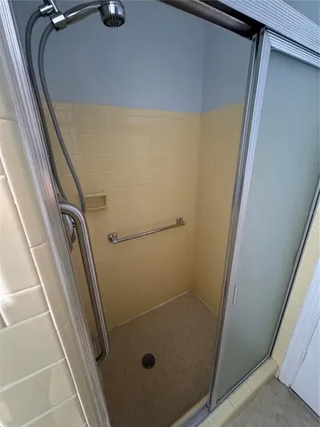 a bathroom with a glass door shower and a sink