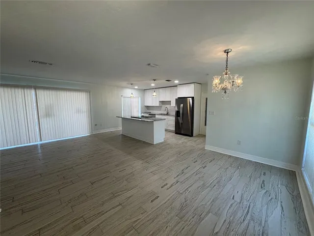 a view of a kitchen with a sink a refrigerator and wooden floor