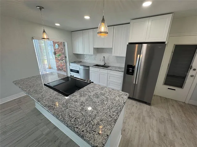a kitchen with stainless steel appliances granite countertop a sink stove and refrigerator