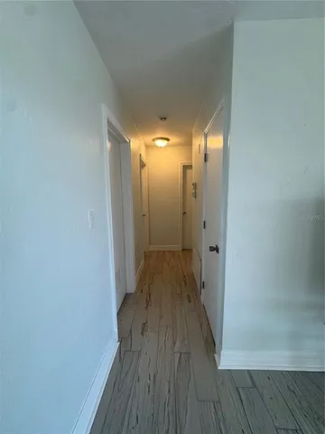 a view of a room with wooden floor