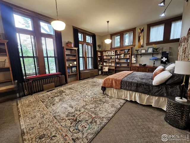 a spacious bedroom with a large bed and a chandelier
