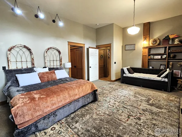 a bedroom with a bed a dresser and bookshelf