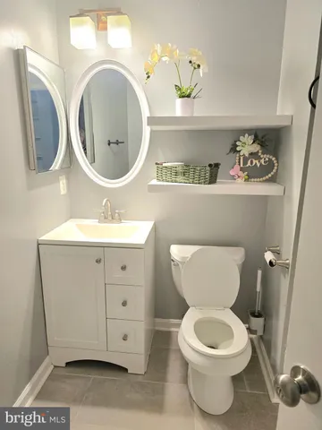 a bathroom with a toilet sink vanity mirror and vanity