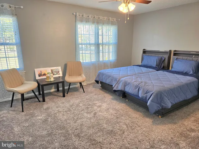 a spacious bedroom with a bed chair and window