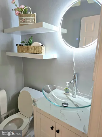 a bathroom with a toilet a sink and a mirror