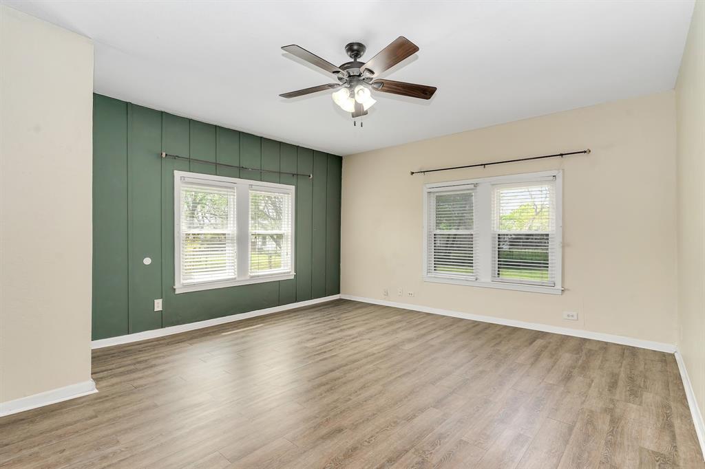 914 Prairie Avenue Cleburne, TX 76033 - Photo 11 of 19 a view of an empty room with wooden floor and a window