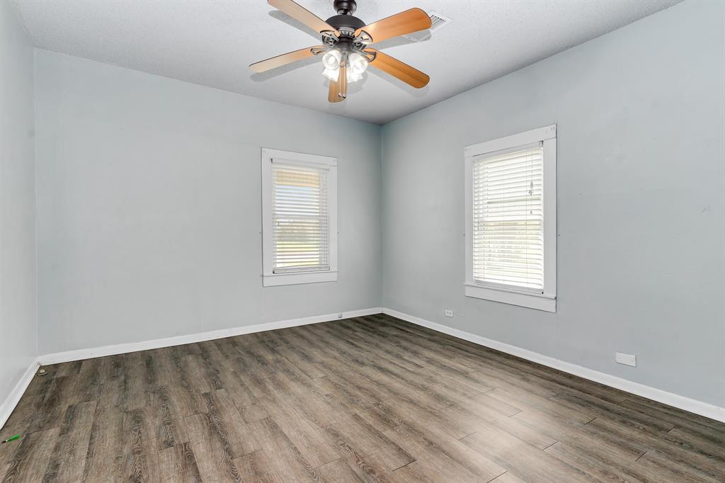 914 Prairie Avenue Cleburne, TX 76033 - Photo 14 of 19 wooden floor in an empty room with a window